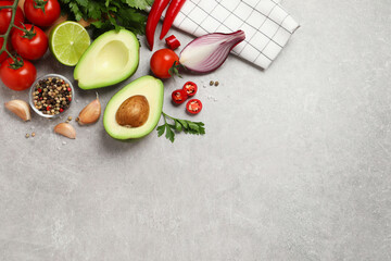 Fresh guacamole ingredients on light grey table, flat lay. Space for text