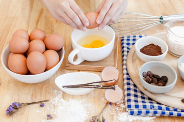 Man in the kitchen cooking a dough. Hands breaks an egg into a bowl ,hands pouring bitten egg ,Baking concept