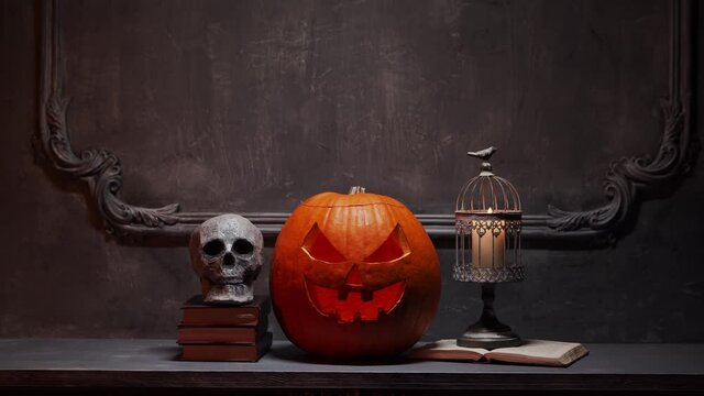 Scary laughing pumpkin and old skull on ancient gothic fireplace. Halloween, witchcraft and magic.