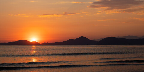 Obraz premium panorâmica de pôr-do-sol laranja na praia no verão e férias