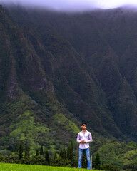Fototapeta na wymiar Man standing in front of mountains in Hawaii 