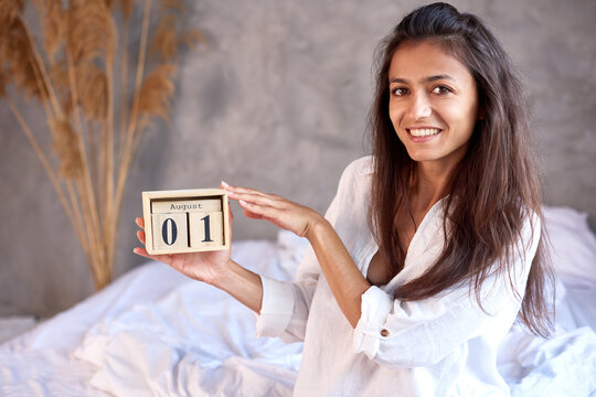 international child free day August 1. happy woman hold wooden perpetual calendar in hands in bedroom.