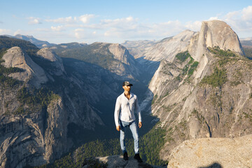 Man hiking and standing in front of a Yosemite valley