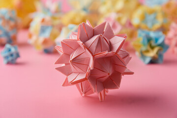 Set of multicolor handmade modular origami balls or Kusudama Isolated on pink background. Visual...