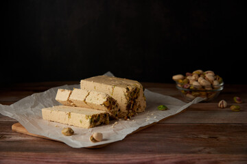 Organic halva with pistachios on a wooden surface. Traditional middle eastern sweets. Jewish,...