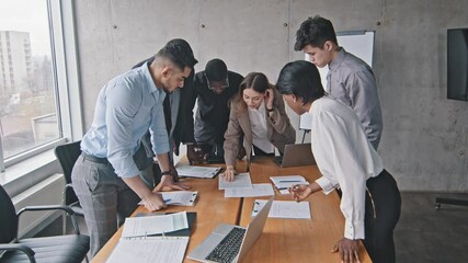 Diverse multiracial business team and caucasian woman mentor leader brainstorm paperwork talk discuss teamwork corporate briefing in office, young female boss explain new project plan training meeting