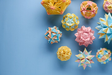 Set of multicolor handmade modular origami balls or Kusudama Isolated on blue background. Visual...