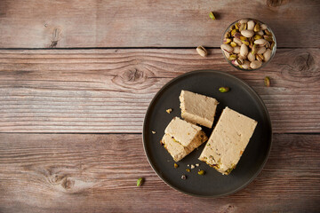 Organic halva with pistachios on a wooden surface. Traditional middle eastern sweets. Jewish,...