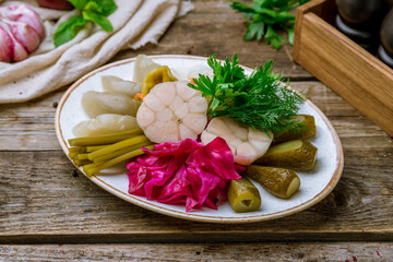 plate of pickles on old wooden table