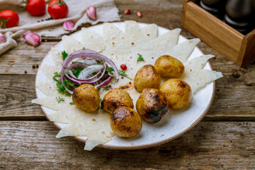 baked mini potatoes fried on coals on old wooden table
