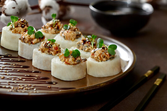 Sushi rolls in mamenori with eel, cream cheese, avocado, daikon, unagi sauce
