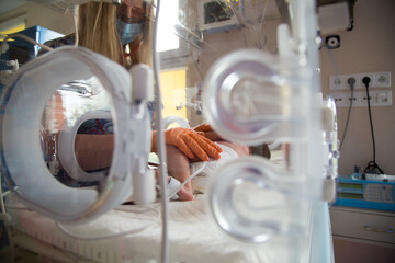 Noworodek w inkubatorze na oddziale neonatologii. Intensywna terapia. 