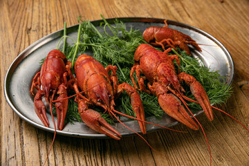 Boiled crayfish in an iron tray on a wooden farmer's table
