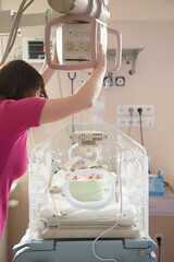 Noworodek w inkubatorze na oddziale neonatologii. Intensywna terapia. 