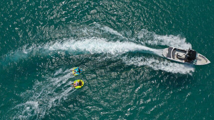 Aerial photo of extreme power boat donut water-sports cruising in high speed in tropical emerald bay