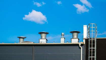 Obraz premium ventilation chimneys on the roof of the industrial building