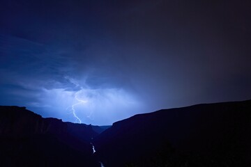 Nocturnal thunderstorm with lightning that makes the river Tarn and the rocks shine in the valley of the Gorges Du Tarn