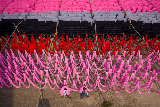 Aerial view of workers hanging thousands of meters of different coloured t-shirt fabrics to dry in Narayanganj, Dhaka, Bangladesh.
