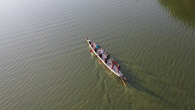 Aerial drone top view of sport canoe rowing synchronous team of athletes competing 