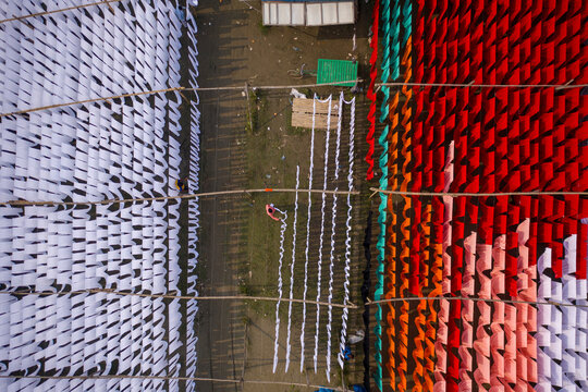 Aerial view of workers hanging thousands of meters of different coloured t-shirt fabrics to dry in Narayanganj, Dhaka, Bangladesh.