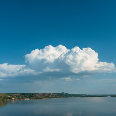 Beautiful blue sky with white clouds over a large lake with steep banks