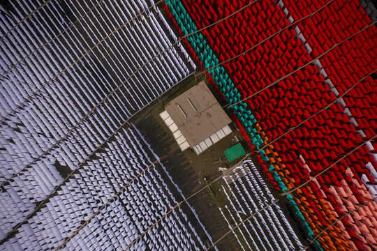 Aerial view of workers hanging thousands of meters of different coloured t-shirt fabrics to dry in Narayanganj, Dhaka, Bangladesh.