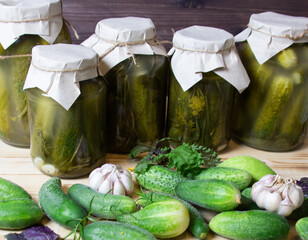 jars of pickled cucumbers on wooden background