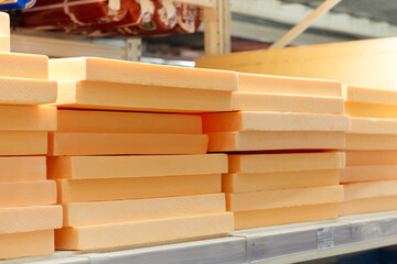 Stacks of orange styrofoam on a shelf in a hardware store.