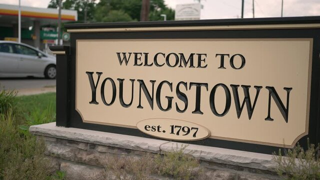 A closeup view of the Welcome to Youngstown sign as traffic passes by on a sunny summer day. Winter version available.
