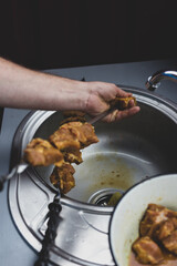 The chef stringing meat on skewers for cooking