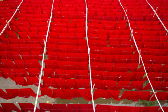 Aerial view of workers hanging coloured t-shirt fabrics to dry in Narayanganj, Dhaka, Bangladesh.