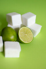 Natural and homemade marshmallows and limes on green background