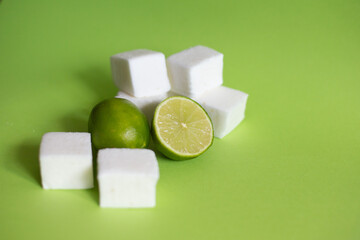 Natural and homemade marshmallows and limes on green background