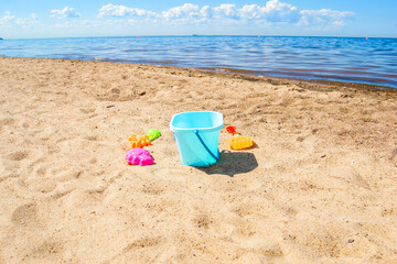 Children's toys for sand on the beach, bucket, scoops and molds. A child at sea.