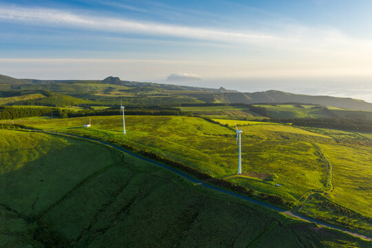 Aerial view of wind turbines in countryside at sunset on Ilha das Flores, Azores islands, Portugal.