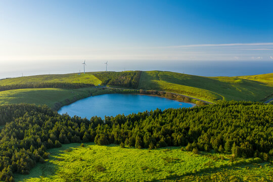 Aerial view of Lagoa da Lomba, a small lake surrounded with vegetation at sunset on Ilha das Flores, Azores islands, Portugal.