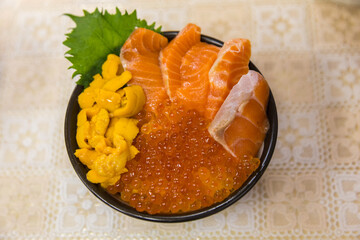 Fresh Seafood bowl in a seafood market in Japan. a sea urchin's gonads and Red caviar or a caviar...