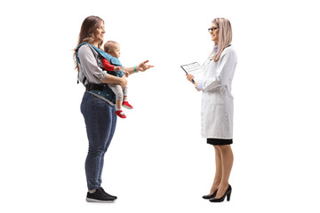 Mother with a baby in a carrier and a female doctor having a conversation