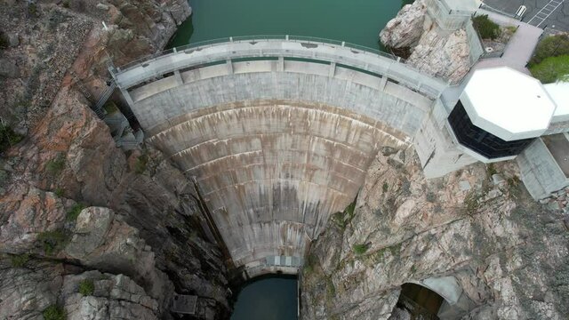 Aerial 4K view of large concrete arch-gravity dam. Drone footage from above Buffalo Bill Dam in Cody, Wyoming.