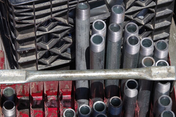 Close-up view of containers with a variety of threaded water pipes