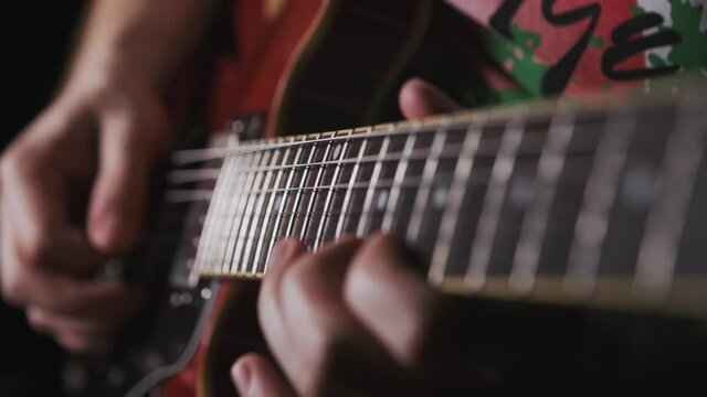 Playing guitar arp chord notes. Musician plays the guitar during a live performance. right hand playing guitar in a bluish lightning. guitar player at a concert rocking audience. just a guitarist