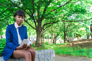 Obraz premium 公園で読書をする黒人女性
