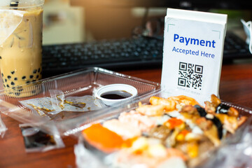 Naklejka na ściany i meble Selective focus to QR code tag with blur Sushi set or Japanese food meal on desk for food delivery payment. Qr code payment concept.
