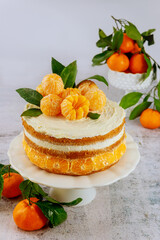 Citrus cake decorated with fresh tangerine and leaves.