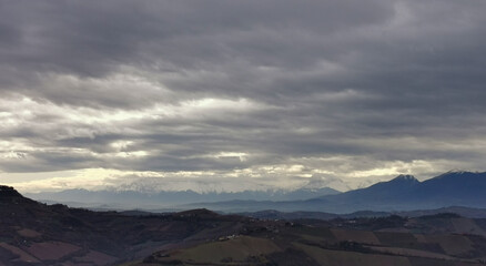 Nuvole grigie sopra le cime innevate dei monti Appennini