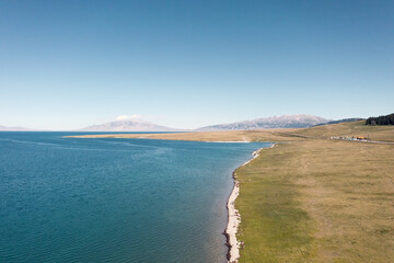 Lake and grassland with a sunny day. Shot in Sayram Lake in Xinjiang, China.