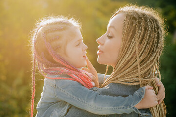 Family and motherhood concept. Mother and child girl playing kissing and hugging. Little daughter...