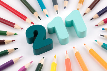 The number 211 is surrounded by a large number of colored pencils
