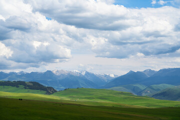 Grassland and mountains in a cloudy day. Photo in Kalajun grassland in Xinjiang, China.