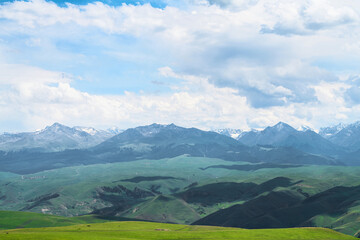 Obraz premium Grassland and mountains in a cloudy day. Photo in Kalajun grassland in Xinjiang, China.